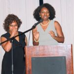 Two women speaking at a podium.